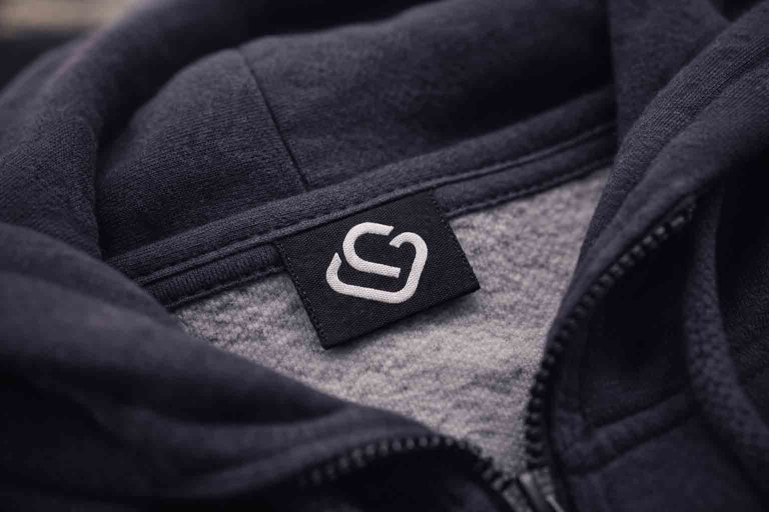 Close-up van een geweven neklabel met subtiel logo in een hoodie