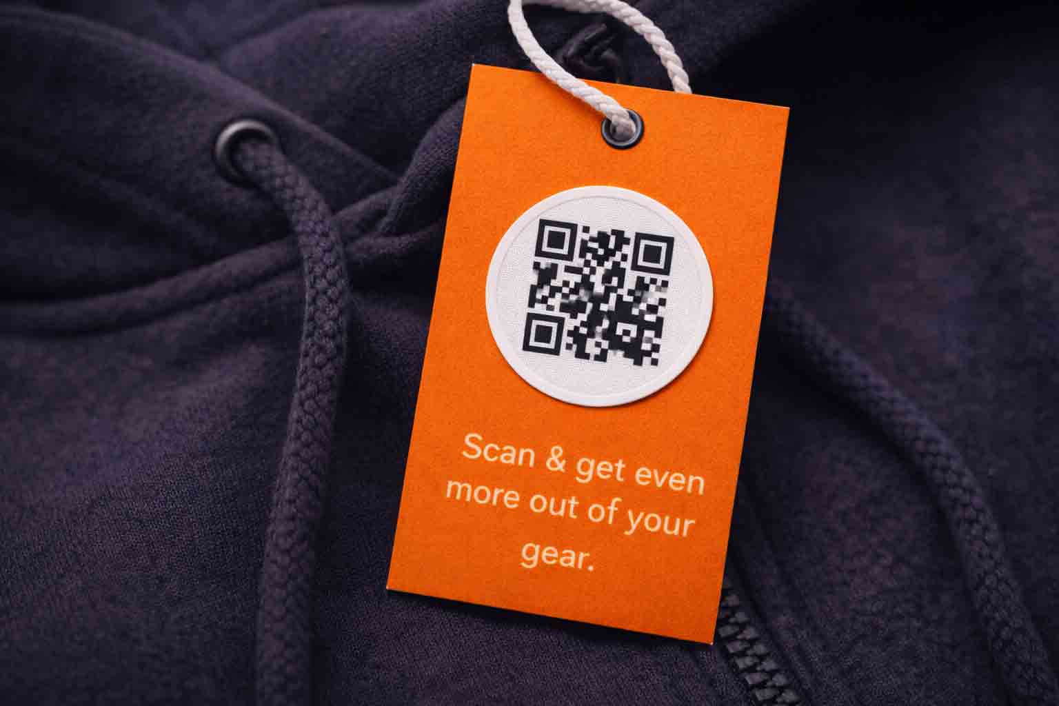 Hangtag aan een hoodie met QR-code en korte merkboodschap