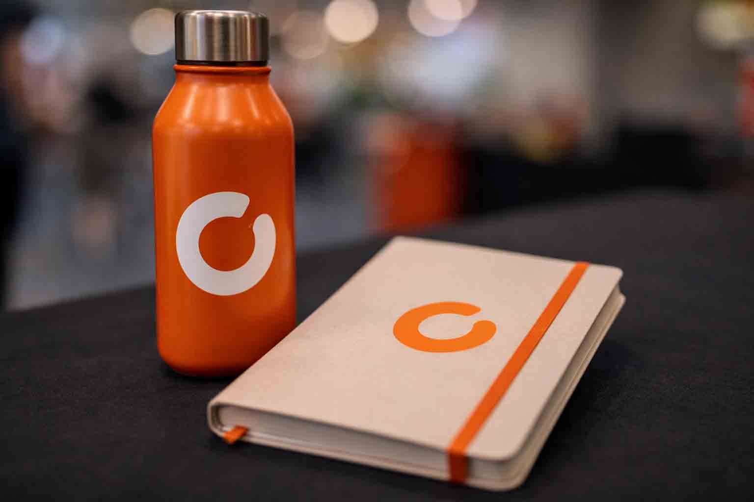 Close-up van een bedrukte drinkfles naast een notitieboek